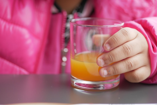 Bambino che tiene un bicchiere di succo d'arancia