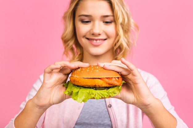 Bambino che tiene un pezzo di hamburger.