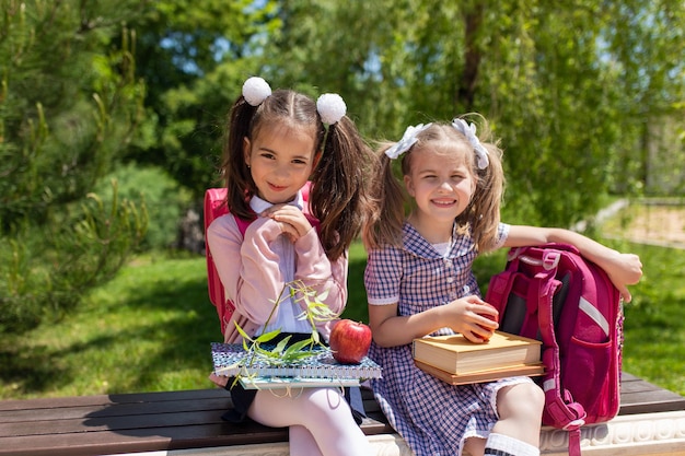 Bambino che va a scuola Due ragazze che tengono libri e mele il primo giorno di scuola