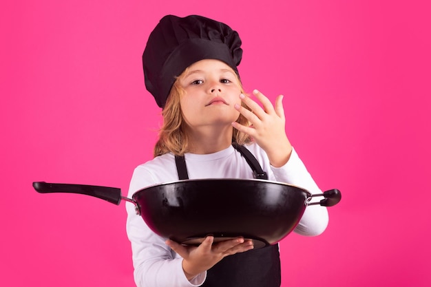 Bambino chef cuoco con padella Bambino in uniforme da cuoco Chef kid isolato su sfondo rosa Bambino carino per essere uno chef Bambino vestito come un cappello da chef