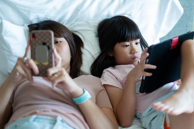 Bambino cinese che gioca smartphone con tablet madre bambino addicted