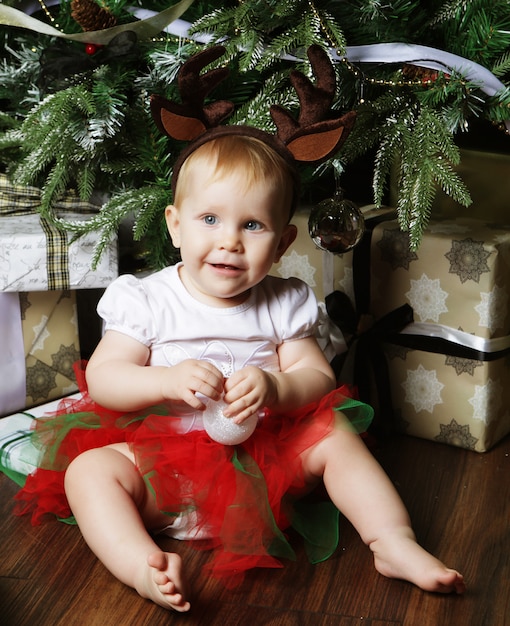 Bambino con albero di Natale e regali