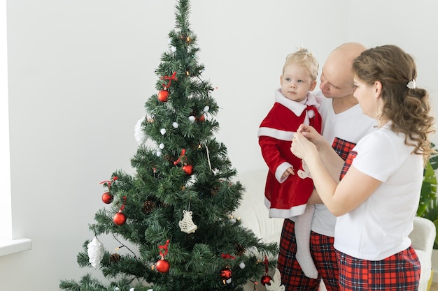 Bambino con apparecchio acustico e impianto cocleare che si diverte con i genitori nella stanza di natale Diversità sorda e concetto di salute