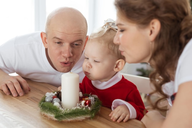 Bambino con apparecchio acustico e impianto cocleare divertendosi con i genitori nella stanza di natale sordo div