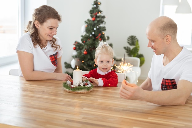 Bambino con apparecchio acustico e impianto cocleare divertendosi con i genitori nella stanza di natale sordo div