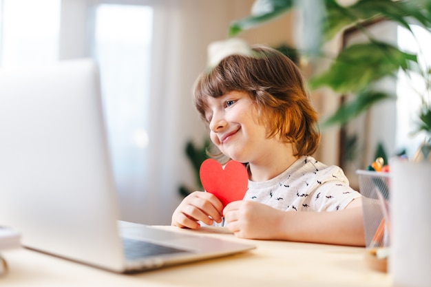 Bambino con biglietto di auguri di San Valentino con una chat video