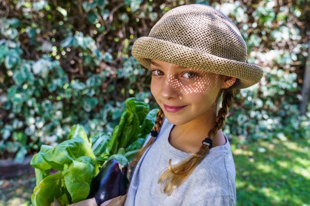 Bambino con cappello di vimini in estate con generi alimentari dal mercato eco-friendly