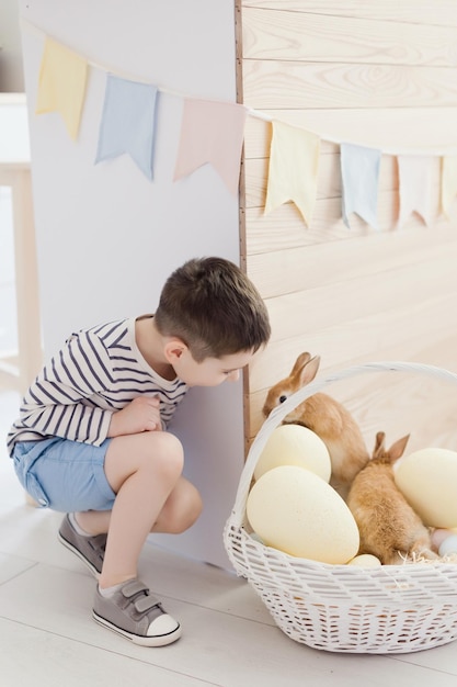 Bambino con coniglio e decorazione pasquale