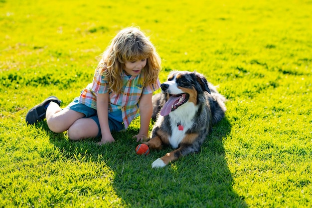 Bambino con cucciolo di cane Il ragazzo gioca con il cane nel parco in estate