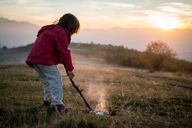 Bambino con fuoco in natura