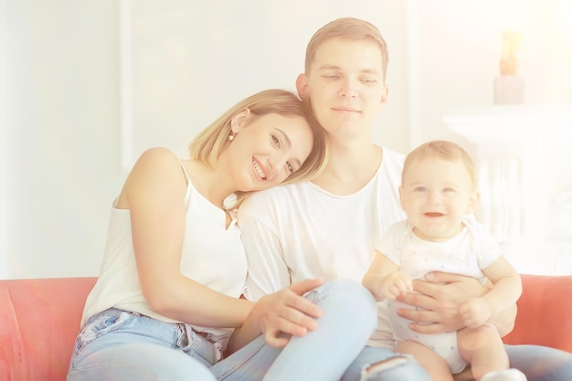 bambino con i genitori in una casa accogliente / sana giovane famiglia mamma papà e bambino, sorriso di felicità