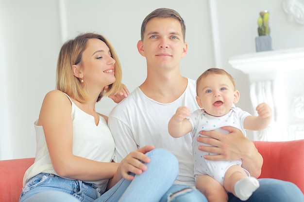 bambino con i genitori in una casa accogliente / sana giovane famiglia mamma papà e bambino, sorriso di felicità