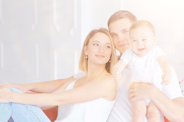 bambino con i genitori in una casa accogliente / sana giovane famiglia mamma papà e bambino, sorriso di felicità