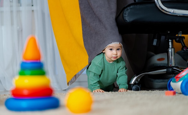 Bambino con i giocattoli seduti sul tappeto a casa Bambino carino che gioca con il giocattolo della piramide Concetto di sviluppo precoce