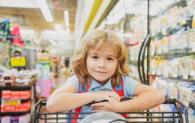 Bambino con il carrello in un negozio di alimentari