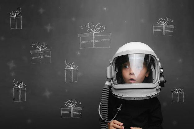 bambino con il casco di un astronauta sogna Natale e regali