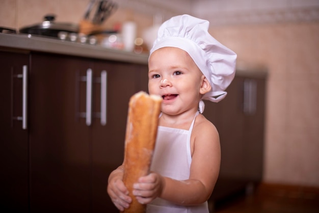 bambino con il pane in mano vestito da cuoco