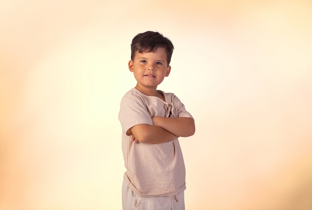 Bambino con le espressioni facciali in una foto in studio su sfondo colorato.