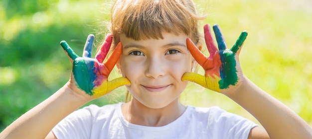 Bambino con le mani dipinte multicolori