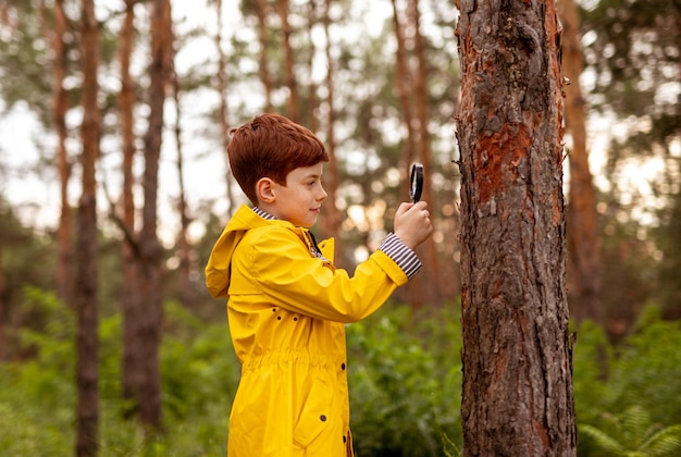 Bambino con lente d'ingrandimento che esplora la natura