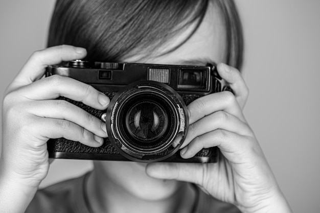 Bambino con macchina fotografica Bambino sorridente allegro con una macchina fotografica Piccolo ragazzo che scatta una foto