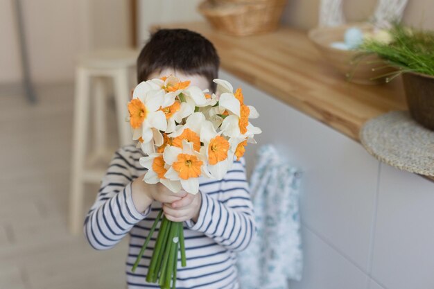 Bambino con narcisi e decorazioni pasquali