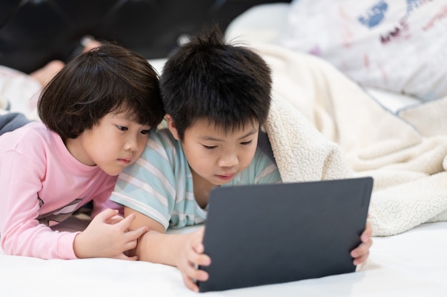 bambino con tablet insieme sul loro letto