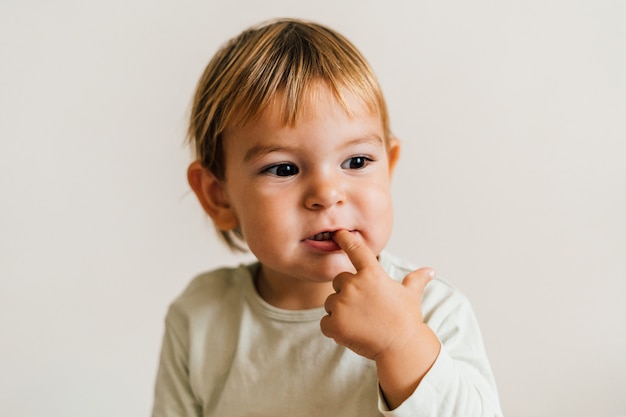 Bambino con un dito in bocca. Concetto di gengive russare dentizione