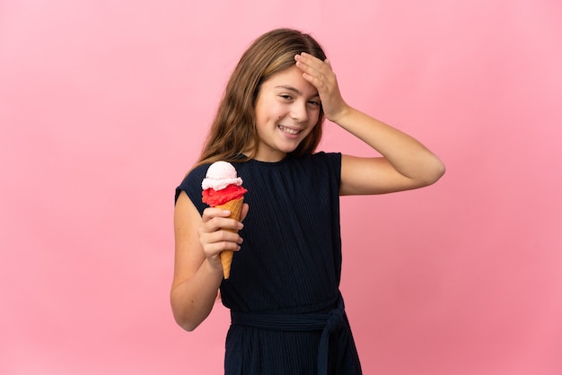 Bambino con un gelato alla cornetta su sfondo rosa isolato che sorride molto