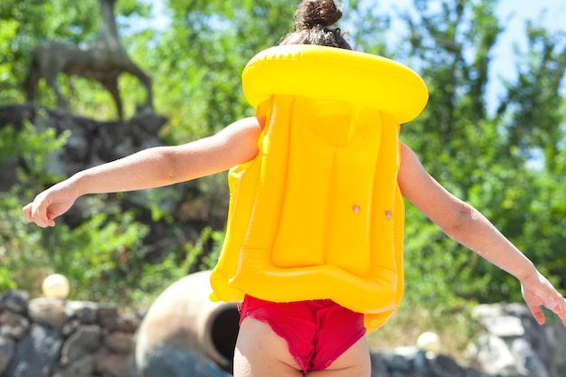 Bambino con un giubbotto di salvataggio in piscina