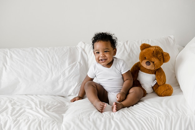 Bambino con un orsacchiotto sul letto