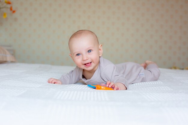 Bambino con un sonaglio sul letto