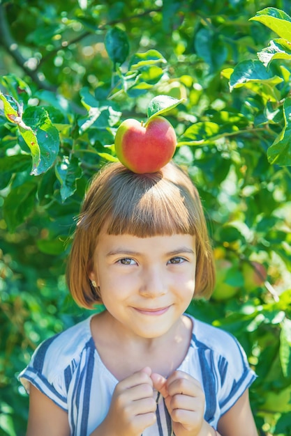 Bambino con una mela in giardino