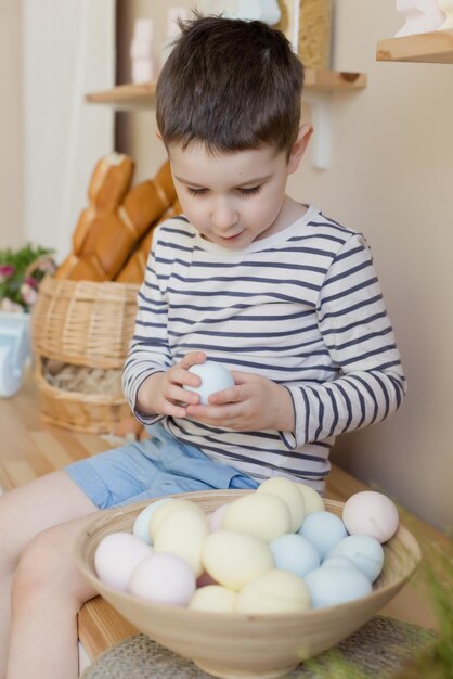 Bambino con uova di Pasqua e decorazioni