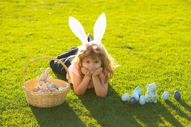 Bambino con uova di Pasqua e orecchie da coniglio all'aperto. Ragazzo carino che ha buona pasqua nel parco. Buona Pasqua.