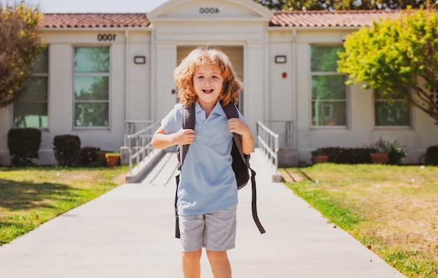 Bambino con zaini nel parco vicino alla scuola Scolaro con zaini all'aperto Giornata della conoscenza Uniforme scolastica