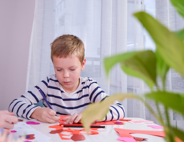 Bambino creato biglietto di auguri fatto in casa Un ragazzino dipinto e colorato con cuori divertenti Regalo per San Valentino Concetto di arti e mestieri