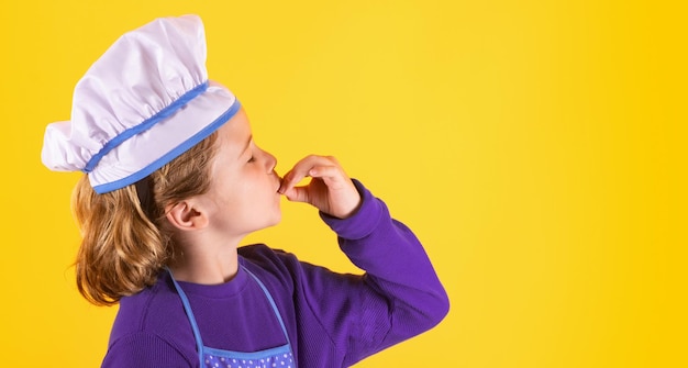 Bambino cuoco con pentola e mestolo Bambino in uniforme da cuoco Chef kid isolato su sfondo giallo Bambino carino per essere uno chef Bambino vestito da cappello da chef