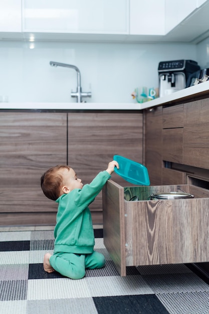 Bambino da solo in cucina Ragazzino che apre il cassetto in cucina Bambino ragazzo in una situazione pericolosa a casa