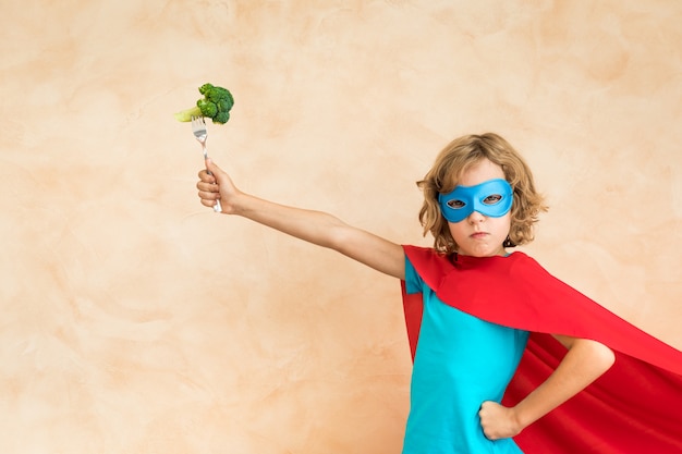 Bambino del supereroe che mangia superfood