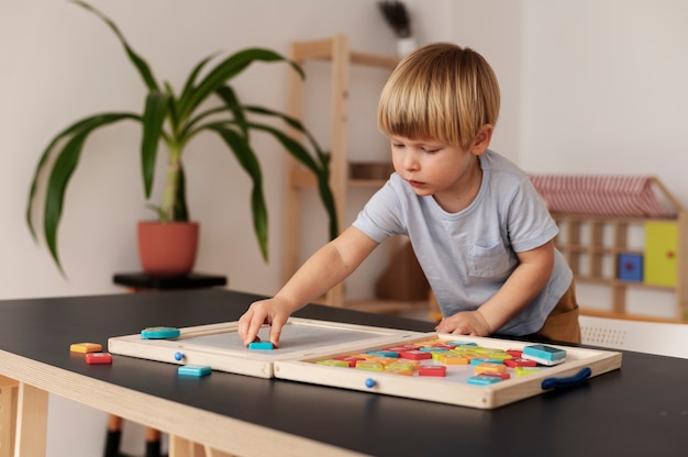 Bambino del tiro medio che gioca con i giocattoli