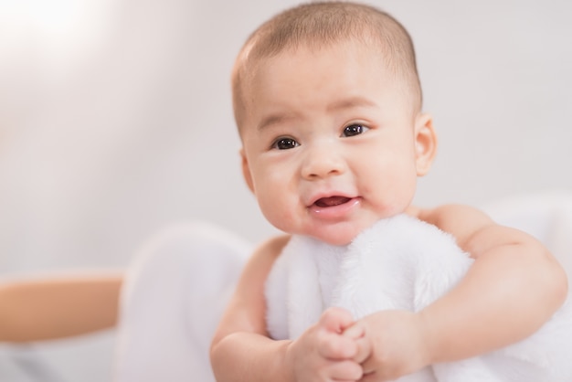 Bambino dell&#39;Asia del ritratto sul letto bianco