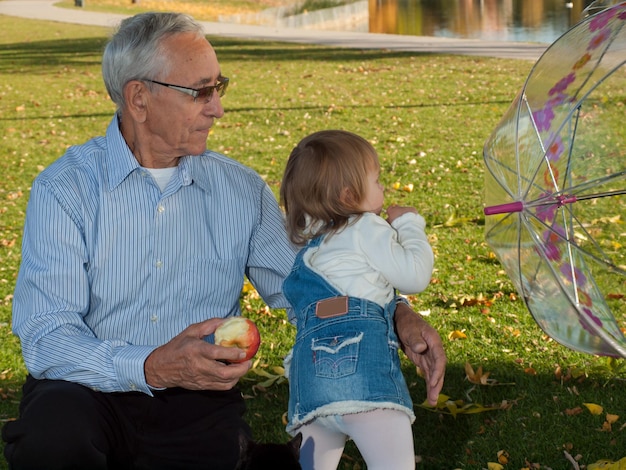 Bambino della ragazza con il nonno nel parco d'autunno.