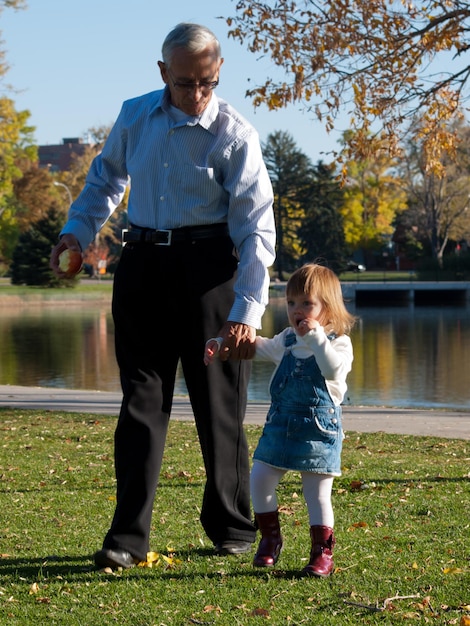 Bambino della ragazza con il nonno nel parco d'autunno.