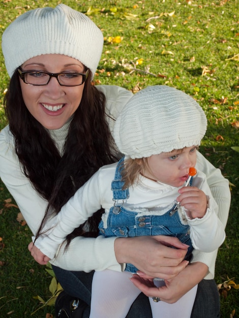 Bambino della ragazza con sua madre nel parco d'autunno.