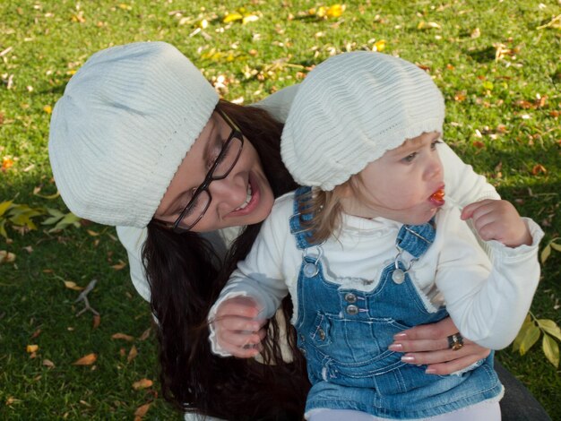 Bambino della ragazza con sua madre nel parco d'autunno.