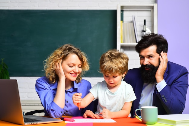 Bambino della scuola elementare con i genitori a scuola settembre inizio delle lezioni allievo carino e