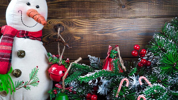 Bambino di neve giocattolo di Natale con albero di Natale giocattolo su sfondo di legno con spazio di copia