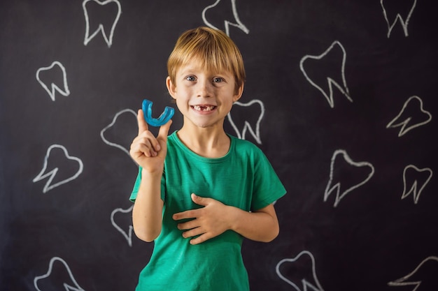 Bambino di sei anni mostra un allenatore miofunzionale Aiuta a pareggiare i denti in crescita e a correggere il morso sviluppa l'abitudine alla respirazione orale Corregge la posizione della lingua