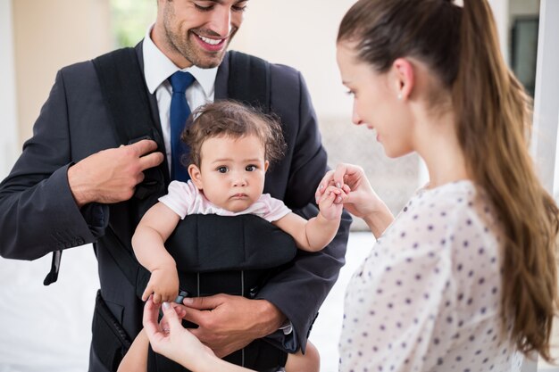 Bambino di trasporto sorridente del padre con la madre